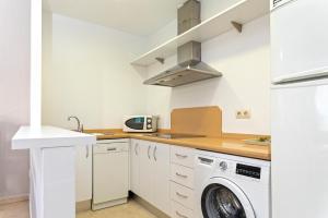 Una cocina blanca con lavadora y secadora. en Genteel Home Arfe Terrace, en Sevilla