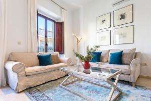 - un salon avec un canapé et une table dans l'établissement Genteel Home Arfe Terrace, à Séville