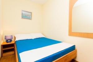 a small bedroom with a blue and white bed at Apartments Radić in Dubrovnik