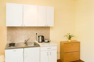 a kitchen with white cabinets and a sink at Apartments Radić in Dubrovnik