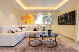 ein Wohnzimmer mit einer weißen Couch und einem Tisch in der Unterkunft Luxury 3 Bedroom Beach Front Apartment in Marbella in Marbella
