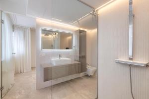 ein Badezimmer mit Waschbecken und Glasdusche in der Unterkunft Luxury 3 Bedroom Beach Front Apartment in Marbella in Marbella + 30 Fotos