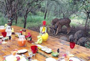 a wooden table with a table with animals around it at Wielewaal Bush Lodge in Marloth Park