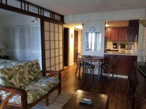 een woonkamer en een keuken met een bank en een tafel bij Ilikai Tower 1 Bedroom City View Condos with Private Lanai & Free Wifi! in Honolulu