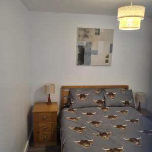 um quarto com uma cama com uma colcha azul com peixes em 2 Bed Flat Right in Centre of Portrush town em Portrush