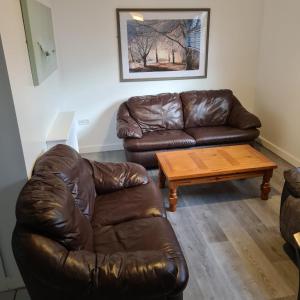 uma sala de estar com um sofá de couro e uma mesa de centro em 2 Bed Flat Right in Centre of Portrush town em Portrush