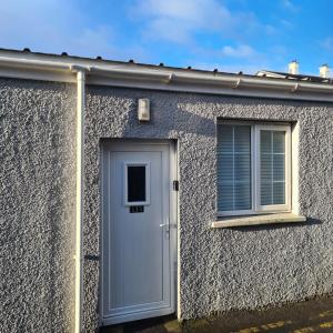 uma casa com uma porta e duas janelas em 2 Bed Flat Right in Centre of Portrush town em Portrush