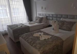 Habitación de hotel con 2 camas y sofá en Harbour Hotel, en Sinope