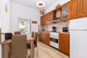 een keuken met houten kasten en een tafel met stoelen bij Villa Georgina in Nisakion