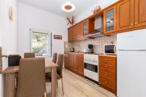 a kitchen with wooden cabinets and a table with chairs at Villa Georgina in Nisakion