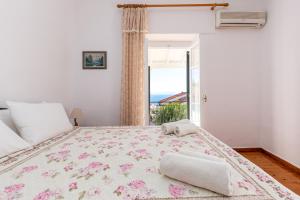 a bedroom with a large bed with a window at Villa Georgina in Nisakion +17 photos