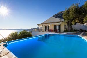 a large blue swimming pool in front of a house at Villa Georgina in Nisakion