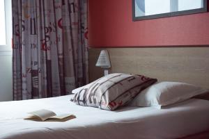 a bedroom with a bed with two books on it at Ace Hotel Annecy in Annecy
