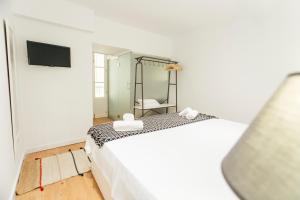 a bedroom with a white bed and a mirror at CSE Pajaritos in Seville