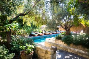 a swimming pool in a garden with trees and plants at Alavya in Alaçatı