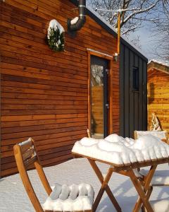a pair of chairs sitting in front of a cabin at Cãsuța de sub nuc in Piatra Neamţ