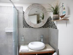 une salle de bain avec un lavabo et un miroir dans l'établissement L'appart de la Ferté - Rue principale de St Valery, à Saint-Valery-sur-Somme