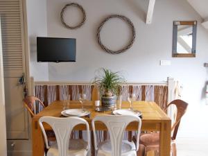 une salle à manger avec une table et des chaises en bois dans l'établissement L'appart de la Ferté - Rue principale de St Valery, à Saint-Valery-sur-Somme