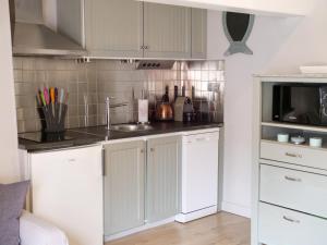 une cuisine avec des armoires blanches et un micro-ondes dans l'établissement L'appart de la Ferté - Rue principale de St Valery, à Saint-Valery-sur-Somme