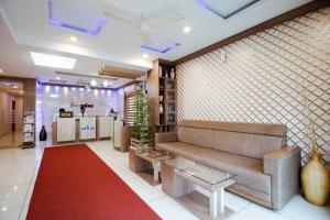 salon z kanapą i czerwonym dywanem w obiekcie Spring Field Billets w mieście Koczin