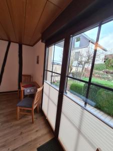 Zimmer mit einem Fenster, einem Stuhl und einem Tisch in der Unterkunft Ferienhaus Winzerauszeit in Ellenz-Poltersdorf