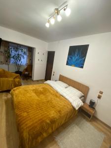 a bedroom with a large bed with a yellow blanket at Casa Felice in Braşov