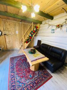 ein Wohnzimmer mit einem Sofa und einem Tisch in der Unterkunft садиба "У Чубчика" in Jaremtsche