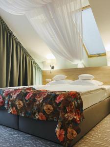 sypialnia z dużym łóżkiem i kwiatowym kocem w obiekcie Gościniec Folwark Nadawki w mieście Białystok
