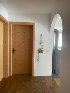 una stanza vuota con una porta in legno e un arco di Ferienwohnung mit idyllischer Aussicht a Klosters
