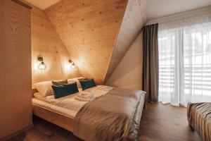 sypialnia z dużym łóżkiem i drewnianym sufitem w obiekcie DOMKI SZMARAGD - Zniżki na Termy - Sauna - Bilard - Stoki Narciarskie -Śniadania w Bukowinie Tatrzańskiej