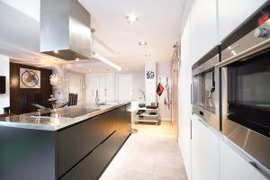 eine Küche mit Küchengeräten aus Edelstahl und einen Flur in der Unterkunft Piso moderno, céntrico y con garaje gratis in Bilbao
