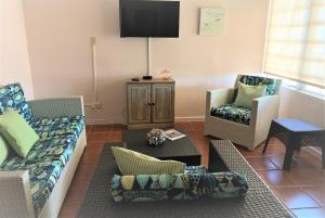 a living room with two couches and a tv at Luquillo Sunrise Beach Inn in Luquillo