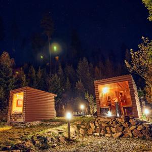 un par de personas de pie fuera de una cabaña por la noche en Škandinávske domčeky-lesná sauna a ubytovanie, en Spišské Bystré