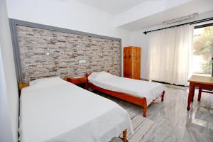 a bedroom with two beds and a brick wall at Sulo Pension in Patara