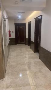um corredor com duas portas e um piso de azulejo em PRIMOTEL Elite As Salamah em Jidá