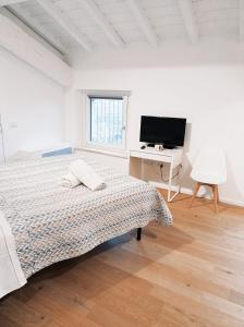 a bedroom with a bed and a desk and a television at Residenze Mazzini in Mantova