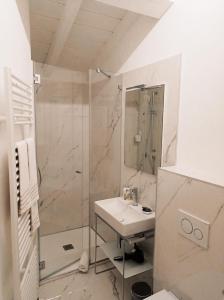 a white bathroom with a shower and a sink at Residenze Mazzini in Mantova