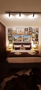 ein Schlafzimmer mit einem großen Bett mit Bildern an der Wand in der Unterkunft Tuzla Trg - Tuzla Square in Tuzla