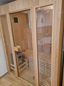 a shower with a glass door in a bathroom at Apartmány Petronela in Makov