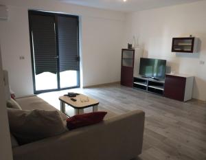 - un salon avec un canapé, une table et une télévision dans l'établissement Apartament in complex rezidential cu parcare., à Timişoara