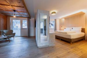 a bedroom with a bed and a mirror at MALI by m3 in Sankt Anton am Arlberg