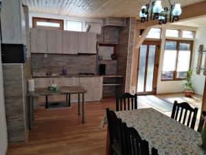 a kitchen with a table and a dining room at Pensiunea Sandra in Sibiel