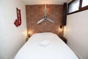 - une chambre avec un lit blanc et un ventilateur de plafond dans l'établissement Loft Indus, à Chamalières