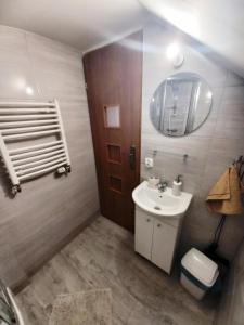 a bathroom with a sink and a toilet and a mirror at Agroturystyka u Joli in Polanica-Zdrój