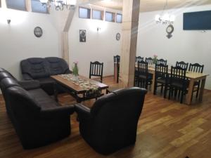 a living room with a couch and a table and chairs at Pensiunea Sandra in Sibiel