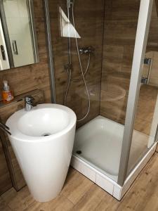uma casa de banho com um lavatório branco e um chuveiro em Appartement Bali em Hüllhorst