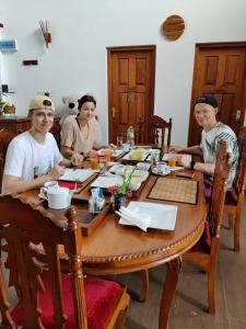 eine Gruppe von Menschen, die um einen Holztisch sitzen in der Unterkunft The Heritage Inn in Kandy