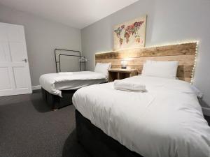 ein Hotelzimmer mit 2 Betten mit weißer Bettwäsche in der Unterkunft Glasgow 2 Bedroom Apartment in Glasgow