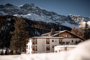 a building with snow covered mountains in the background at Hotel Cristallo in Solda
