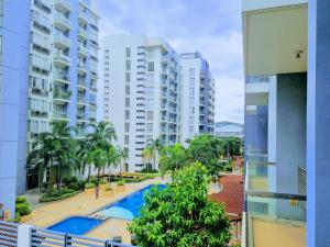 an apartment balcony with a swimming pool and buildings at One Palm Tree Villas Condo Across NAIA Terminal 3 in Manila